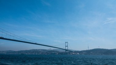  İstanbul 'daki Ortakoy sahilinden İstanbul Köprüsü, karşı kıyısı ve tur teknesi manzarası