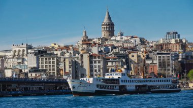  İstanbul, Türkiye 08 Nisan 2023 Galata kule manzaralı şehir hatları feribotu Galata Köprüsü 'nü geçiyor.
