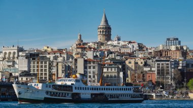  İstanbul, Türkiye 08 Nisan 2023 Galata kule manzaralı şehir hatları feribotu Galata Köprüsü 'nü geçiyor.