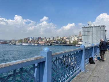 İstanbul, Türkiye 19 Nisan 2023 İstanbul, Golden Horn 'daki Galata Köprüsü' nde yaşlı adam balıkçılık yapıyor. Galata Köprüsü 'nden olta balıkçılığı çok popüler..
