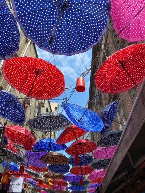 Sokak dekorasyonu ile renkli açık şemsiyeler sokak üzerinde binalar arasında asılı