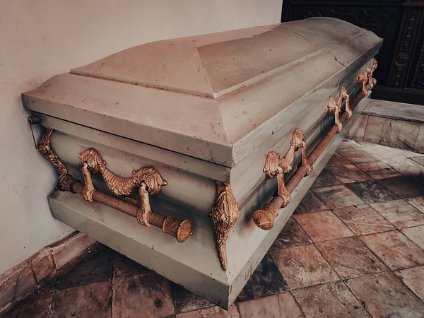 墓地で葬儀や埋葬の前にチャペルや葬儀場で金の装飾が施された金属製の棺のショットを閉じます — ストック写真