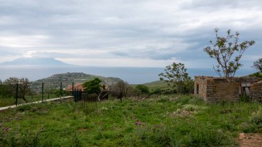 Yağmurlu bir günde Gökçeada 'nın Eski Bademli Gliki köyünden kırsal köy ve deniz manzarası. Eski Bademli - Gliki Köyü, Ege Denizi ve Yunan adası Gökçeada, Canakkale Türkiye 'den Samothrace manzarası. Imbros Adası panoramik şehir manzarası