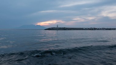 Günbatımı, Yunan adası Semendireği ve Gökçeada Kalekoy 'daki deniz feneri manzarası. Imbros Adası Canakkale, Türkiye