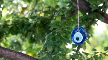 Mavi nazar boncuğu bir ağaç dalında asılı bir iple. Geleneksel Uğursuz Göz Madalyonu. Türkiye 'de ulusal bir sembol ve koruyucu.