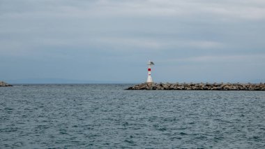 Günbatımı, Yunan adası Semendireği ve Gökçeada Kalekoy 'daki deniz feneri manzarası. Imbros Adası Canakkale, Türk
