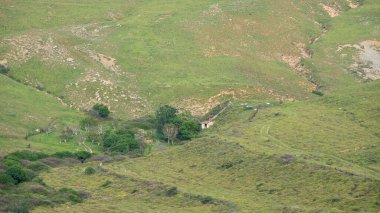 Baharda dağların arasında terk edilmiş küçük bir ev ya da barınak. Bahar mevsiminde dağ manzarası.