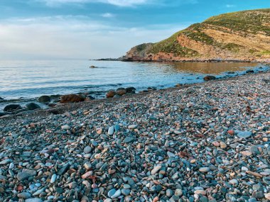 Kalekoy deniz feneri ve Gökceada Imbros Adası Kalekoy limanının gün batımında sahil manzarası. Çanakkale, Türkiye