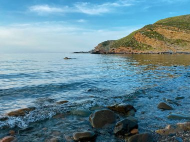 Kalekoy deniz feneri ve Gökceada Imbros Adası Kalekoy limanının gün batımında sahil manzarası. Çanakkale, Türkiye