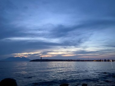 Kalekoy deniz feneri ve Gökceada Imbros Adası Kalekoy limanının gün batımında sahil manzarası. Çanakkale, Türkiye