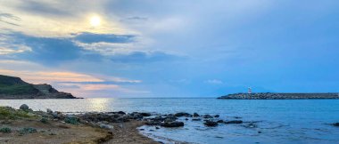 Kalekoy deniz feneri ve Gökceada Imbros Adası Kalekoy limanının gün batımında sahil manzarası. Çanakkale, Türkiye