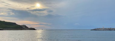 Kalekoy deniz feneri ve Gökceada Imbros Adası Kalekoy limanının gün batımında sahil manzarası. Çanakkale, Türkiye