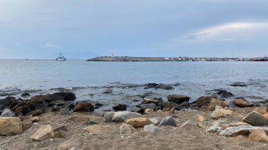 Kalekoy deniz feneri ve Gökceada Imbros Adası Kalekoy limanının gün batımında sahil manzarası. Çanakkale, Türkiye