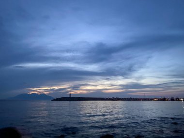 Kalekoy deniz feneri ve Gökceada Imbros Adası Kalekoy limanının gün batımında sahil manzarası. Çanakkale, Türkiye