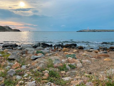 Kalekoy deniz feneri ve Gökceada Imbros Adası Kalekoy limanının gün batımında sahil manzarası. Çanakkale, Türkiye