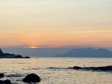 Anakkale, Gökçeada 'daki Yldzkoy plajından gün batımında Semendirek adasının manzarası