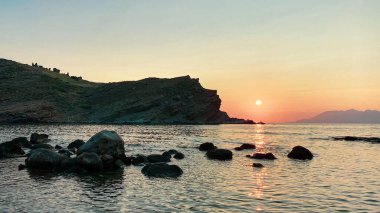 Anakkale, Gökçeada 'daki Yldzkoy plajından gün batımında Semendirek adasının manzarası