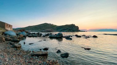 Anakkale, Gökçeada 'daki Yldzkoy plajından gün batımında Semendirek adasının manzarası