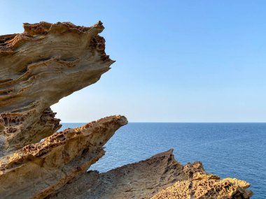 Gökçeada (Yıldizkoy-Blue körfezi) ufuk çizgisinde deniz manzarası ve solunda kayalık bir çıkıntı vardır. Gökçeada, Imbros Adası, Canakkale, Türkiye