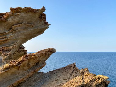 Gökçeada (Yıldizkoy-Blue körfezi) ufuk çizgisinde deniz manzarası ve solunda kayalık bir çıkıntı vardır. Gökçeada, Imbros Adası, Canakkale, Türkiye