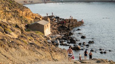 Gökçeada, Canakkale, Türkiye 2 Temmuz 2023: Gkeada 'nın kuzeyinde bulunan Yıldizköy halk plajının keyfini çıkaran insanlar. Körfez, ulusal deniz parkı statüsünde korunuyor..
