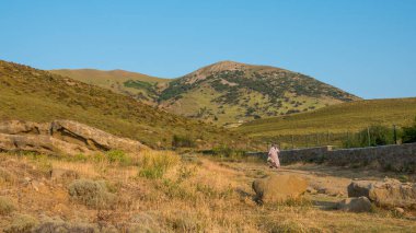 Gökçeada 'nın Yıldizköy ilçesinde vadide yürüyen yaşlı bir köylü kadın. Çanakkale, Türkiye