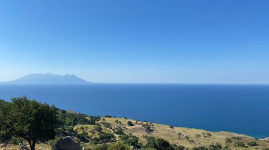 Gökçeada (Imbros) kıyı şeridi manzaralı ve arkasında Samothrace Yunan adası var. Tepeky köyü, Naralt-Pinarbasi bölgesi, Ege Türkiye