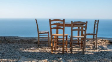 Gökçeada (Imbros) kıyı şeridi ve ahşap sandalyeli ve masalı şirin bir köy çay bahçesi manzarası. Tepeky köyü, Naralt-Pinarbasi bölgesi, Ege Türkiye
