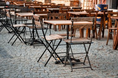 Bir kafenin önüne konmuş ahşap katlanır sandalye ve masalar.