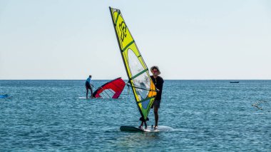 Gökçeada, Canakkale Türkiye 29 Temmuz 2023; Ege Denizi 'nin tadını çıkaran rüzgar sörfçüleri ve açık gökyüzüne karşı Gökçeada Kefalos Körfezi' nde esen rüzgar. Imbros Adası. 