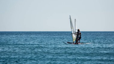 Gökçeada, Canakkale Türkiye 29 Temmuz 2023; Ege Denizi 'nin tadını çıkaran rüzgar sörfçüleri ve açık gökyüzüne karşı Gökçeada Kefalos Körfezi' nde esen rüzgar. Imbros Adası. 