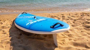 Kürek tahtası (sörf tahtası) kumlu bir sahilde, deniz altyapısı olan