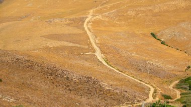 Sarı çimenli vadi manzarası, yeşil maki bitkileri ve Gökçeada 'da bir yaz günü patika. Hava görüntüsü. Çanakkale, Türkiye