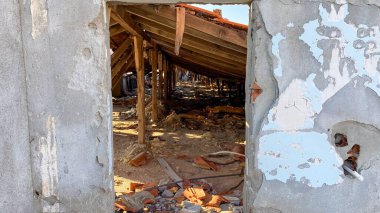 Terk edilmiş ve yıkılmış eski bina, kiremitler ve inşaat molozlarındaki bir çatının iç manzarası