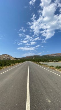 Düz asfalt yol ve yeşil göletli doğal manzara