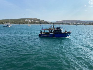 Seferihisar, İzmir, Türkiye, 12 Eylül 2023 Sack Teos marinasında demirli bir balıkçı teknesi denize açılıyor.