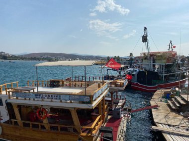 Sigacik, İzmir, Türkiye 14 Eylül 2023: Balıkçılık ve turistik günlük tekne turu yatlarıyla küçük Sigacik limanı. Sigacik, İzmir 'in Seferihisar kentinde popüler bir turizm merkezi..