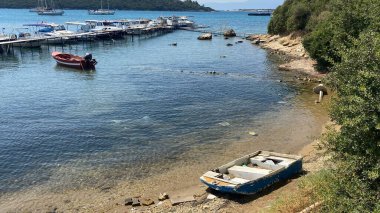 Seferihisar, İzmir, Türkiye 6 Eylül 2023 Seferihisar Sack körfezine demir atmış balıkçı tekneleri ve eski bir ahşap iskele.