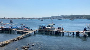 Seferihisar, İzmir, Türkiye 6 Eylül 2023 Seferihisar Sack körfezine demir atmış balıkçı tekneleri ve eski bir ahşap iskele.