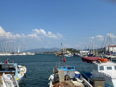 Urla, İzmir, Türkiye 10 Eylül 2023 Limandaki liman limanında bulunan ve Urla, İzmir, Türkiye 'de lüks yatları olan balıkçı tekneleri.