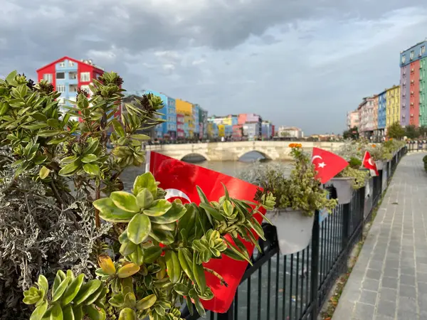  Silivri, İstanbul, Türkiye 6 Kasım 2023 Silivri nehri üzerinde renkli evler ve Türk bayraklarıyla birlikte yaya köprüsü manzaralı. Silivri, İstanbul 'un turistik bir sahil beldesi.