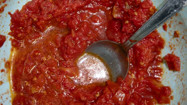 Tomato sauce in a pan with a spoon close-up. Preparation of Italian tomato sauce.