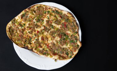 Geleneksel lezzetli Türk yemekleri. Siyah arka planda izole edilmiş beyaz tabakta kıymalı lahana eti.