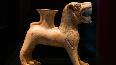 Çanakkale, Türkiye - 19 Kasım 2023 Antik seramik aslan heykeli bronz çağdan kalma şarabı siyah arka planda içtiği için. Arkeoloji Müzesinde Antik Sanat Sergisi