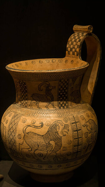 Ancient greek earthenware pot with patterns on a black background.