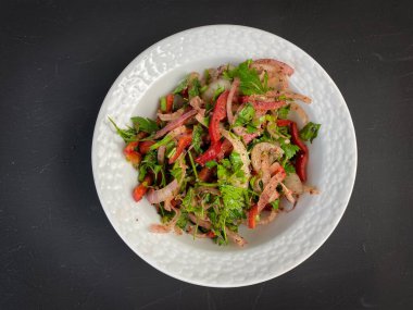 Soğanlı salata, maydanoz, kırmızı biber ve koyu arkaplanda porselen kasede domates. Türk pizzası için aperatif, Pita pizza Lahmacun