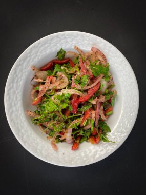 Soğanlı salata, maydanoz, kırmızı biber ve koyu arkaplanda porselen kasede domates. Türk pizzası için aperatif, Pita pizza Lahmacun