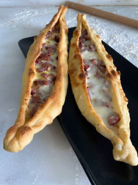 Geleneksel Türk ev yapımı sosisli ve peynirli pide ekmeği. Geleneksel Türk mutfağı fırında pide. Yerel yemekler, Türk pizzası..