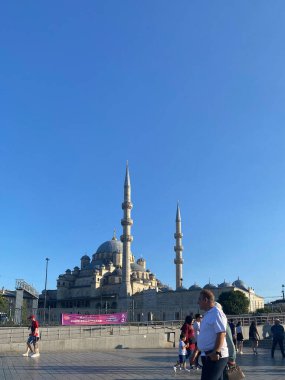Istanbul, Turkey, Aug. 2023 Tourists and locals pass by the New Mosque in Eminn Istanbul. The mosque is one of the most visited mosques in the world