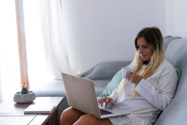 Evde dizüstü bilgisayarla çalışan bir kadın.